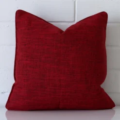 Very close photo of red maroon cushion. The shot shows the linen material and square dimensions with more clarity.