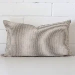 Bold rectangle cushion positioned in front of white brickwork. Its striped style pops on the designer fabric.