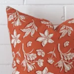 A detailed shot of this rust floral cushion cover that has linen fabric and a square size.