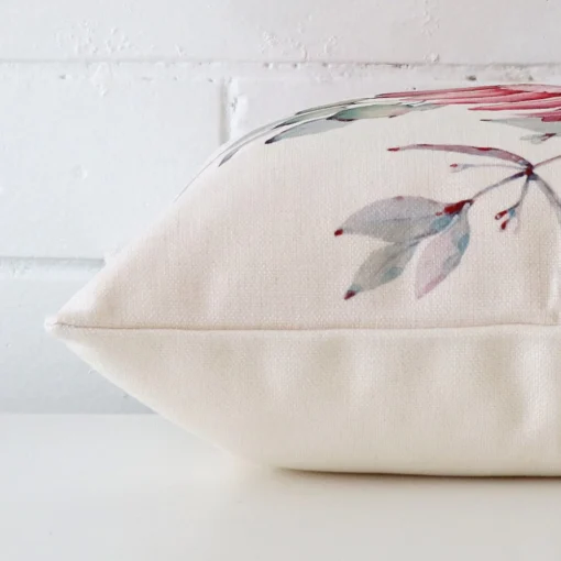 Floral cushion cover laid on its back side. The image shows a side-on view of the linen material and its square dimensions.