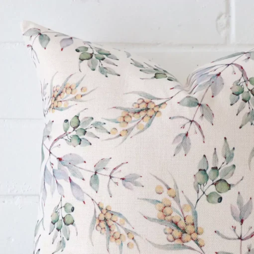 Magnified view of this linen cushion cover’s corner showing a floral design and its square size.