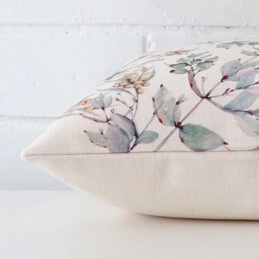 Square cushion laid flat. This view shows the floral style and linen fabric from side on.