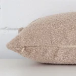 Lateral viewpoint of this boucle rectangle cushion. The beige colour is shown from the side showing the front and rear panels.