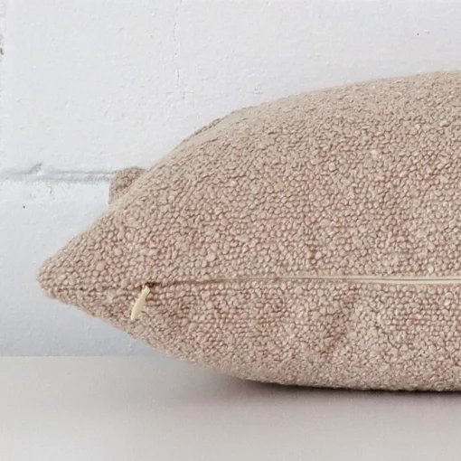 Lateral viewpoint of this boucle rectangle cushion. The beige colour is shown from the side showing the front and rear panels.