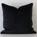 An eye-catching velvet square cushion cover featuring a hue that is black.