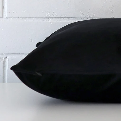 Velvet black cushion laying on its side. The square size is visible.