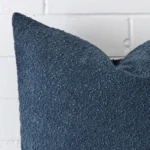 Close up image of boucle rectangle cushion. The image allows you to see the blue hue thoroughly.