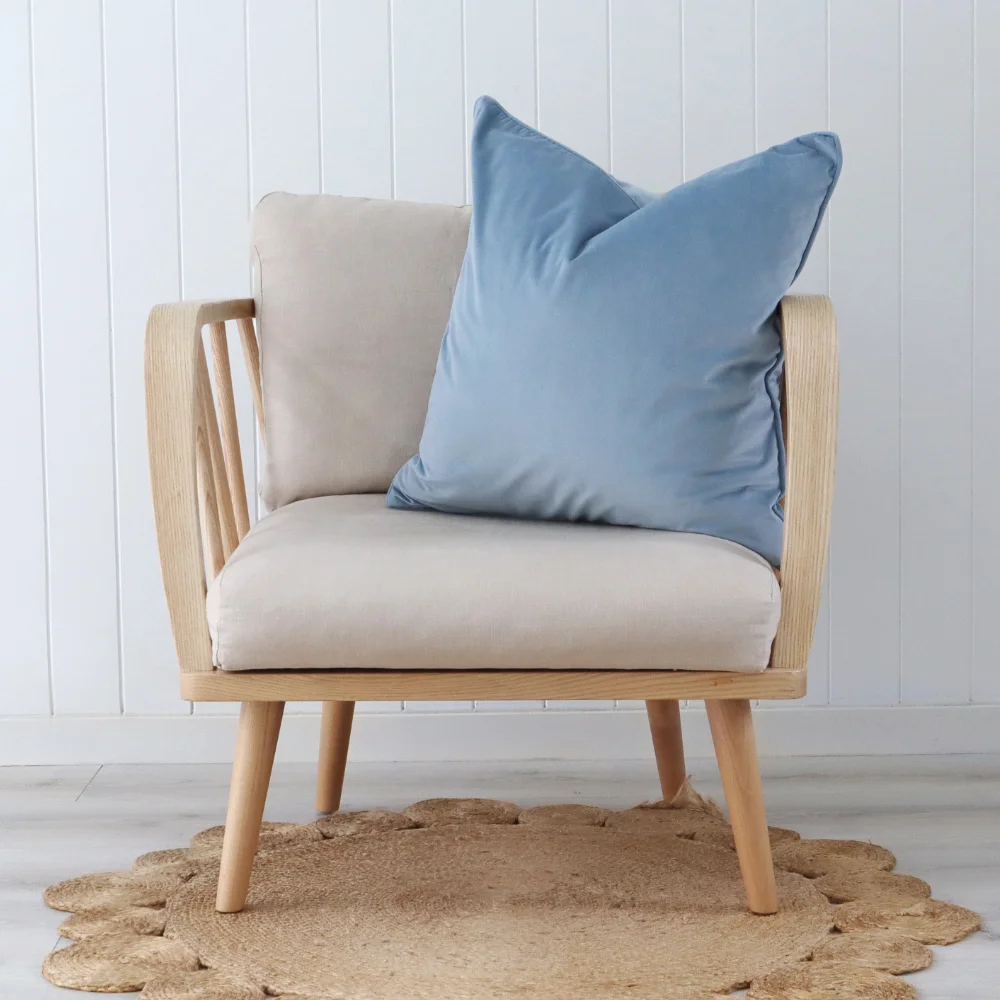 A blue cushion has been arranged in the corner of a chair.