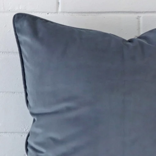 Very close photo of blue grey cushion. The shot shows the velvet material and square dimensions with more clarity.