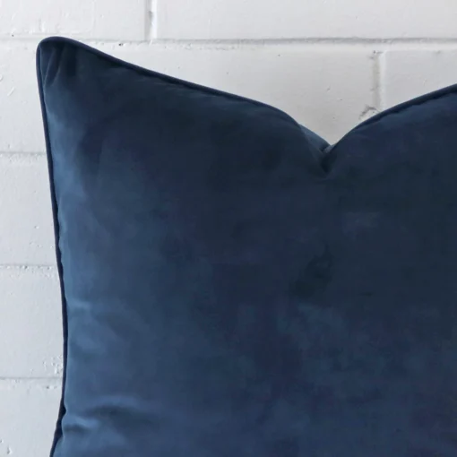 A macro image of the top left corner of this velvet cushion. It is possible to see the finer detail of the square shape and blue colour.