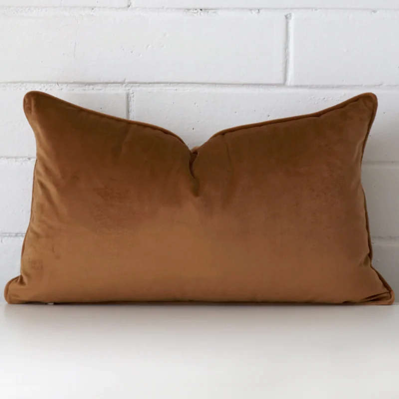 bronze-velvet-cushion-cover-rectangle-sc1036-30 Bronze velvet cushion cover in front of a white wall. It has a large size and is made from a velvet material.