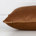 Bronze cushion cover laid on its back side. The image shows a side-on view of the velvet material and its rectangle dimensions.