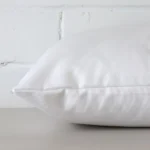 A side view of white cushion that has outdoor fabric and a rectangle size.