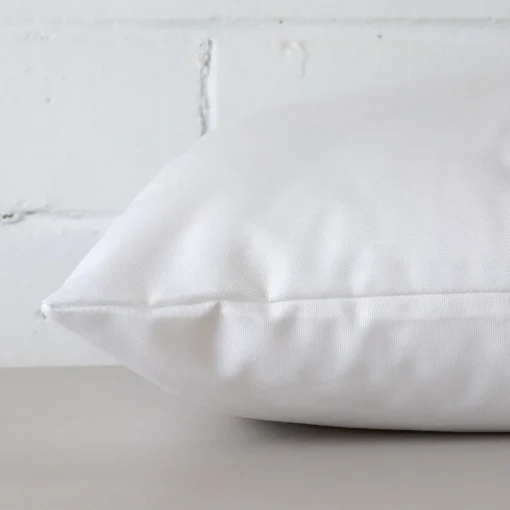 A side view of white cushion that has outdoor fabric and a rectangle size.