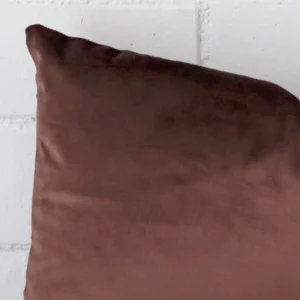 Focused view of rectangle cushion cover. The shot shows details of its velvet material and chocolate brown colour.