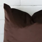 The corner of this velvet SIZE cushion cover is shown close up. The chocolate brown colour is shown in greater detail.