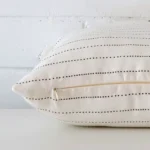 Square cushion laid flat. This view shows the striped style and linen fabric from side on.
