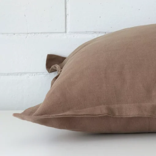 Clay cushion laid horizontally. This perspective shows the edge of the linen fabric and its square shape.