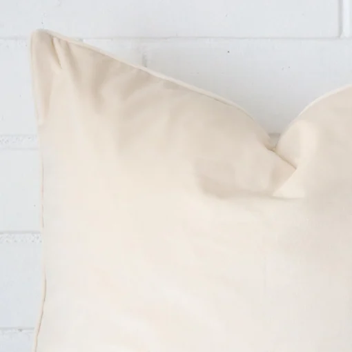 Magnified view of this velvet cream cushion cover’s corner in a square size.