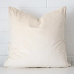 Striking square cream cushion cover featuring a velvet fabric.