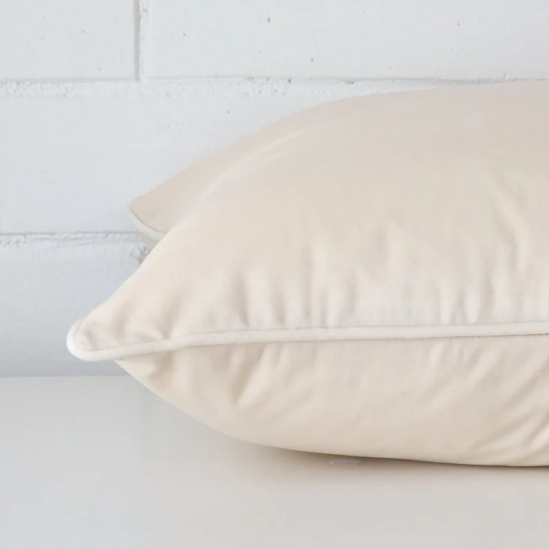 Side edge of square cushion. The velvet material and cream colour can be seen from this lateral viewpoint.