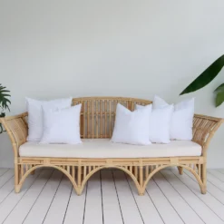 A set of 5 faux feather outdoor cushion inserts positioned on a sofa.