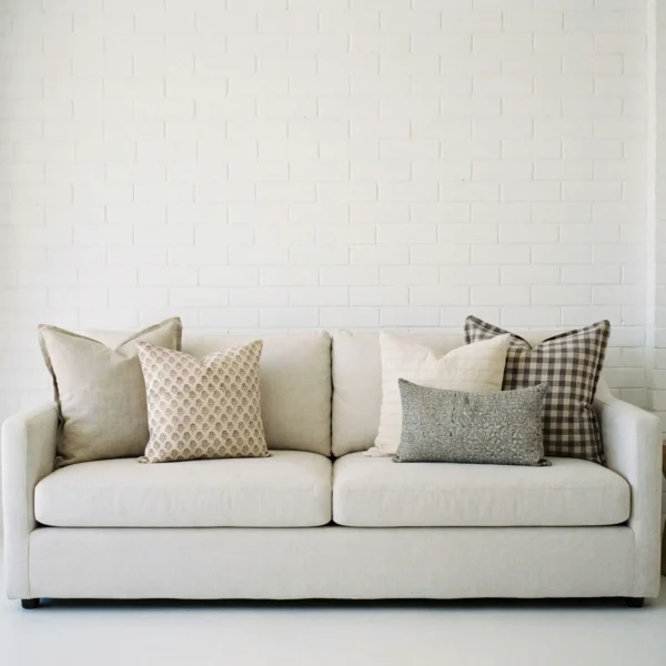 Darcy cushions displayed on sofa with soft beige, grey and check patterned cushions.