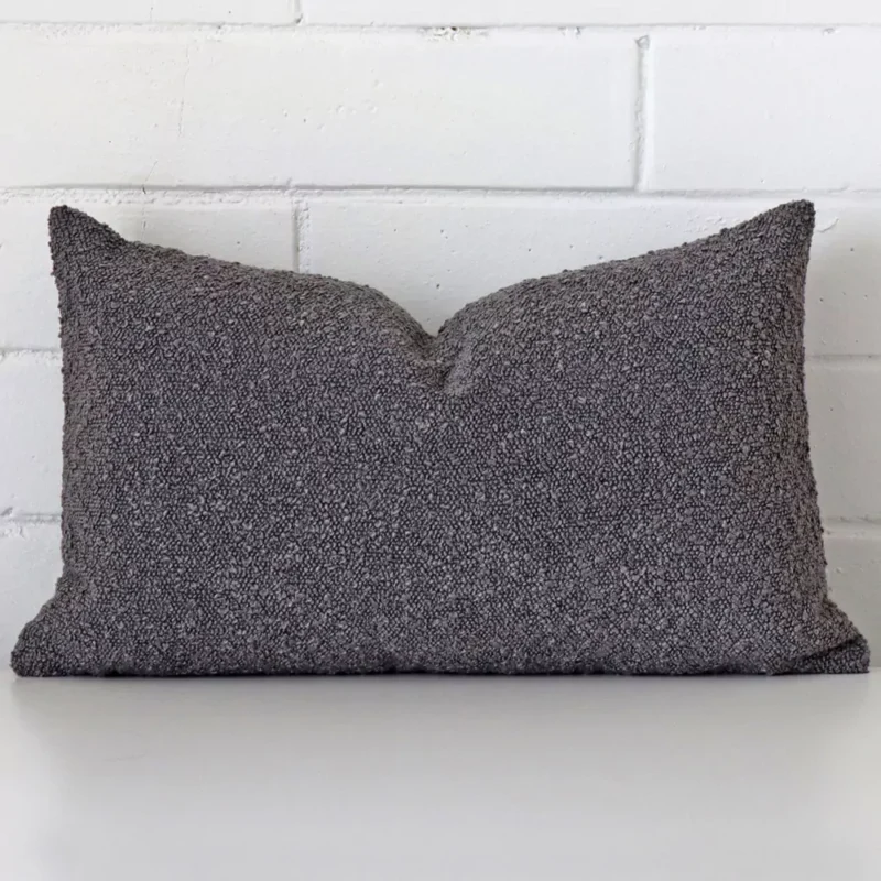 dark-grey-boucle-cushion-cover-rectangle-sc1030-30 Dark grey cushion cover sits against a white wall. It is constructed from a superior looking boucle material and has rectangle dimensions.