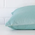 A side view of duck egg cushion that has velvet fabric and a square size.