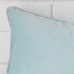 The corner of this velvet rectangle cushion cover is shown close up. The duck egg colour is shown in greater detail.