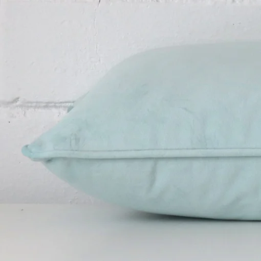 Side angle shot of velvet rectangle cushion cover. It shows a duck egg hue.