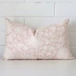 Close up view showing a corner of this floral linen cushion in a rectangle size and with light pink colouring.