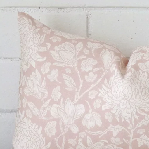 Zoomed in visual of linen rectangle cushion cover in light pink. The intricacies of its floral design are visible.