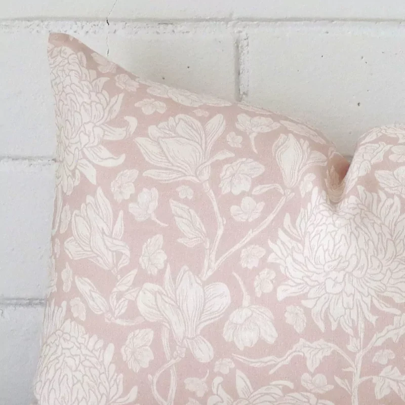 Zoomed in visual of linen rectangle cushion cover in light pink. The intricacies of its floral design are visible.
