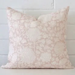 An eye-catching linen square cushion cover featuring a hue that is light pink. It has a unique floral style.