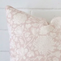 A detailed shot of this light pink floral cushion cover that has linen fabric and a square size.