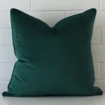 A premium velvet emerald green cushion in a square size.