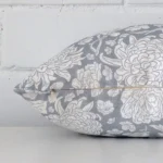 Light blue floral cushion cover laying sideways against brick wall. The rectangle size and linen material are shown highlighting the seams.