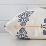 A side view of light blue patterned cushion that has linen fabric and a square size.