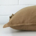 The edge of this linen square cushion in fawn is shown. The shot shows the front and rear panels.