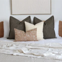 Four designer bed cushions add a pleasing look to the wooden bed.