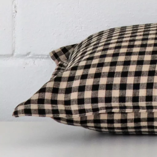 Designer cushion laying on its side. The gingham design and its rectangle size are visible.