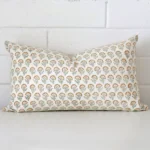 An attractive floral designer cushion in front of a white brick wall. It has a rectangle shape.