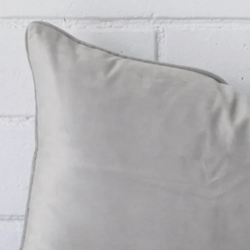 Cropped shot of top left corner of this flint grey cushion cover. This viewpoint shows the velvet fabric and rectangle shape with more precision.