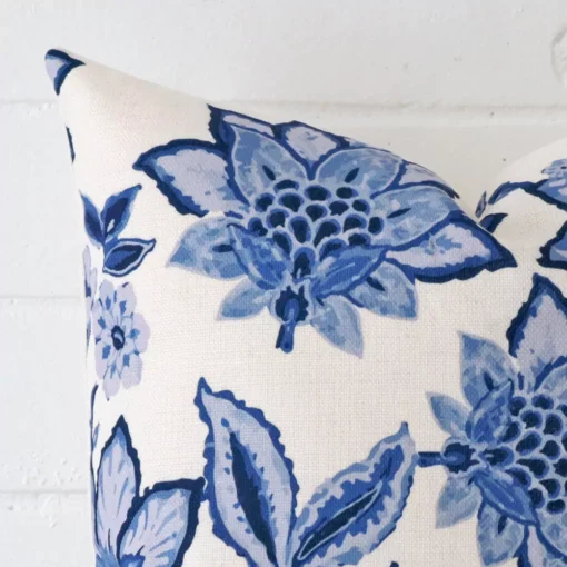 Close up view showing a corner of this floral linen cushion in a square size.