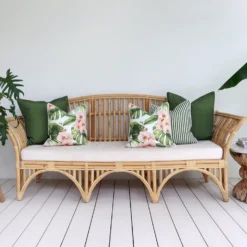 A set of 5 floral olive outdoor sofa cushions on a rattan seat creating a chic and relaxing vibe.