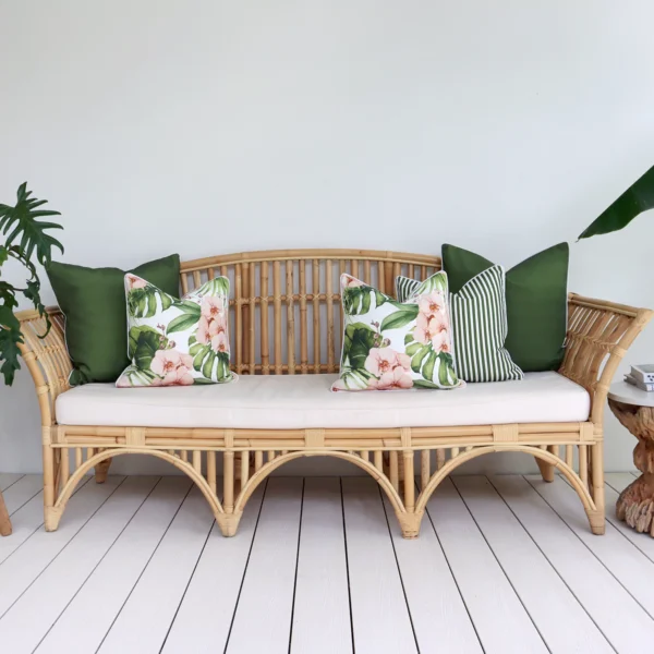 A set of 5 floral olive outdoor sofa cushions on a rattan seat creating a chic and relaxing vibe.