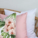 A magnified view of this set of three floral pink outdoor cushion covers corner shows greater detail.