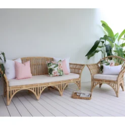 Outdoor seating with a set of 5 floral pink outdoor sofa cushions on it.