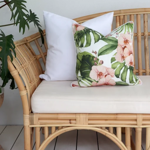 A floral pink sofa cushion paired with a solid white cushion creating a serene ambiance for your outdoor relaxation.